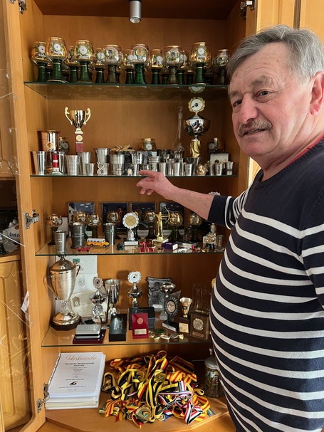 Herbert Sinz vor den Trophäen eines Sportlerlebens